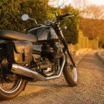 Essai moto guzzi v7 : moto noire sur route au golden hour